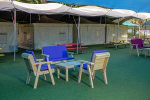 a group of chairs and a bench under a tent at The Camping Site Hamat Gader in Kinneret