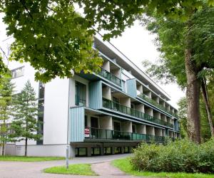 an apartment building with green balconies and trees at Jalaka Apartment with sauna in Pärnu