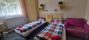 two beds and a couch in a room at Penzion Svojanov in Svojanov