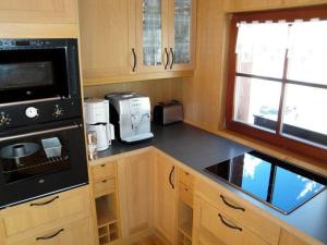 a kitchen with wooden cabinets and a black counter top at Ferienhaus-Bergtraum-Ferienwohnung-Lilli in Kurort Oberwiesenthal