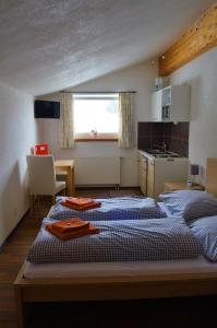 ein Schlafzimmer mit 2 Betten und eine kleine Küche in der Unterkunft Landhaus Cornelia in Berwang