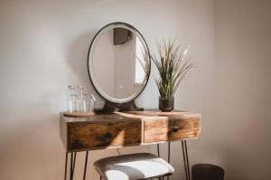 a mirror on top of a wooden dresser with two chairs at The Lodge by Cefn Tilla in Usk