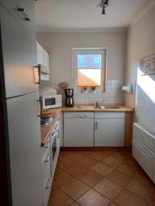 a kitchen with a white refrigerator and a sink at VALIF6001-Haus-Lindenallee-II in Vadersdorf