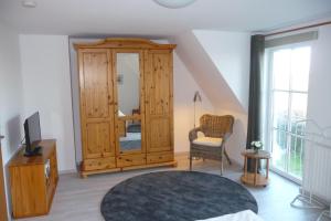 a room with a large wooden cabinet and a mirror at VALIF6001-Haus-Lindenallee-II in Vadersdorf