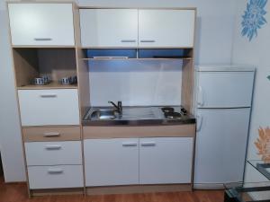 a small kitchen with white cabinets and a sink at Apartman Spaseski in Ohrid