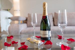 Una botella de vino y dos copas en una mesa en Belgrade Waterfront Apartments - River View, en Belgrado 22 fotos más