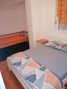 a bedroom with two beds and a bench in it at Apartman Spaseski in Ohrid