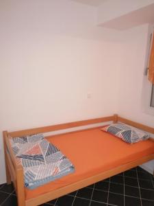 an orange bed with two pillows on it in a room at Apartman Spaseski in Ohrid +7 photos