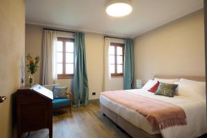 1 dormitorio con 1 cama y 1 silla azul en Cascina Binè, en Novi Ligure