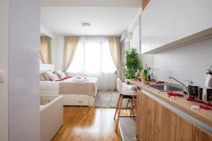 eine Küche mit einem Waschbecken und ein Schlafzimmer mit einem Bett in der Unterkunft Belgrade Waterfront Apartments - River View in Belgrad