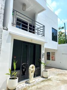 uma casa branca com duas plantas à sua frente em Breezes Villa em Ngingas