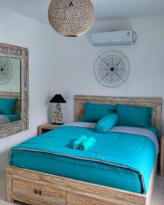 a bedroom with a bed with blue sheets and a mirror at Breezes Villa in Ngingas +46 photos