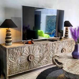 a large wooden dresser with a television on top of it at Breezes Villa in Ngingas