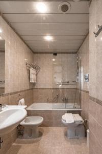 a bathroom with a tub and a toilet and a sink at BB Hotels Smarthotel Re Milano Nord in Sesto San Giovanni
