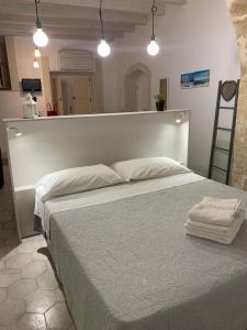 a bedroom with a large bed with two towels on it at Casa Graziosa in Siracusa