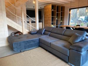 um sofá de couro numa sala de estar com uma mesa em Mazurskie Klimaty - domy z widokiem em Tomaszkowo