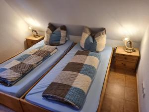 two beds in a room with pillows on them at Lüttjes Diekhuus in Butjadingen OT Tossens