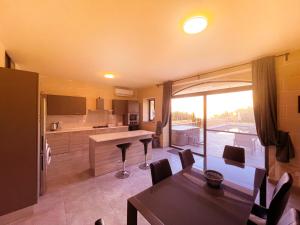 una cucina e una sala da pranzo con tavolo e sedie di Si-Ku Holiday Home with Private Pool and Hot Tub a Xagħra
