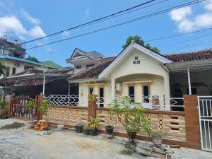 une maison avec une clôture en bois devant elle dans l'établissement OYO 90998 Wisma Pinggir, à Tanjung Pinang