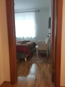 um quarto com uma cama, uma janela e uma cadeira em Bellavista em Vrnjačka Banja