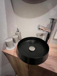 a black sink on a wooden counter in a bathroom at 城崎温泉 小宿 紬 tsumugi in Toyooka