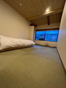 a bedroom with a bed and a large window at 城崎温泉 小宿 紬 tsumugi in Toyooka