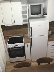 a small kitchen with a stove and a microwave at Aurora Guest House in Nesebar