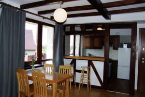 a kitchen and dining room with a table and chairs at Mazurski Zakątek-Apartamenty in Mikołajki