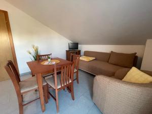 uma sala de estar com uma mesa e um sofá em Apartmani Petra Španjol em Banjol