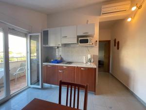 a kitchen with white cabinets and a table and a microwave at Apartments and boat rental Petra Španjol - crane and moorings in Banjol