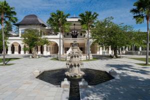 une fontaine en face d'un bâtiment avec des palmiers dans l'établissement Jumeirah Bali, à Uluwatu