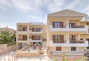 a large yellow building with balconies at Aloustina Apartments in Archangelos