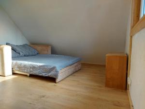 Słoneczny domek ze stawem i wędkowaniem في Żdżary: غرفة نوم صغيرة بسرير وارضية خشبية