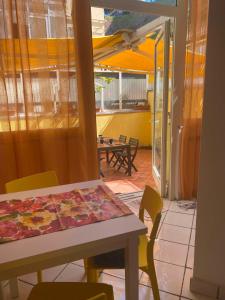 mesa y sillas en una habitación con mesa y patio en Molly's House Appartamento a Posillipo, en Nápoles
