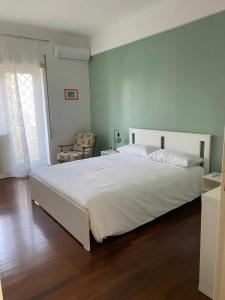 1 dormitorio con 1 cama blanca grande y 1 silla en Molly's House Appartamento a Posillipo, en Nápoles