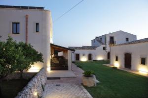a courtyard of a house with a green lawn at Casal Sikelio in Cassibile