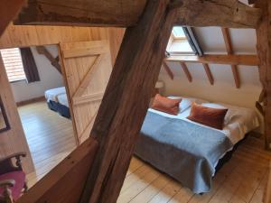 an attic room with a bed and two windows at Erfgoed & Logies Den Heijkant in Moergestel