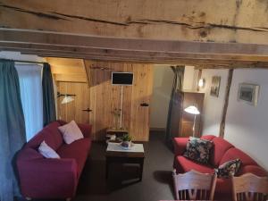 a living room with two red couches and a table at Erfgoed & Logies Den Heijkant in Moergestel