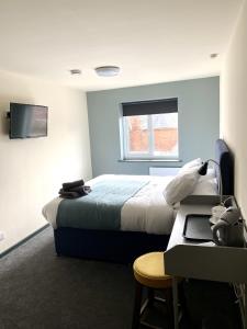 Habitación de hotel con cama y escritorio con ordenador portátil en The Bridge Inn en Tenbury