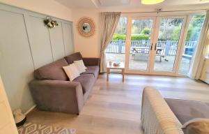 a living room with a couch and a sliding glass door at 147 Snowdon Drive, Glan Gwna in Caernarfon