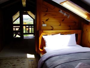 ein Schlafzimmer mit einem Bett in einem Zimmer mit einem Fenster in der Unterkunft Mazurski Zakątek-Apartamenty in Mikołajki