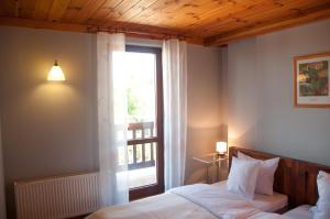 a bedroom with a bed and a window and a lamp at Mazurski Zakątek-Apartamenty in Mikołajki