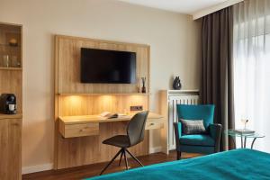 a hotel room with a television and a bed at Best Western Premier Alsterkrug Hotel in Hamburg