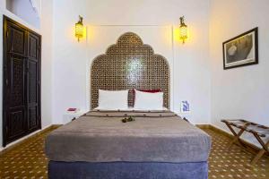 een slaapkamer met een groot bed met een groot hoofdeinde bij Riad Dabachi in Marrakesh