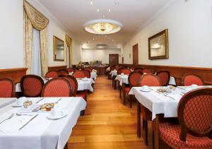 
a dining room table with chairs and tables at Hotel Raffaello; Sure Hotel Collection by Best Western in Rome
