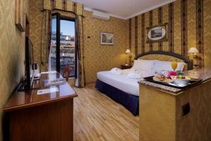 
a hotel room with a bed, table and a mirror at Hotel Raffaello; Sure Hotel Collection by Best Western in Rome
