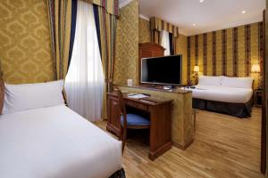 
a hotel room with a large bed and a television at Hotel Raffaello; Sure Hotel Collection by Best Western in Rome
