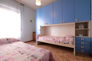 1 dormitorio con 2 camas y armarios azules en Malibù 5 Pineto Vacanza, en Pineto