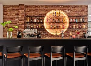 a brick wall with a bar with stools at 1891 Garni Hotel in Kraków