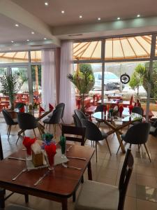a restaurant with wooden tables and chairs and windows at HOTEL PARIS Relax Zone in Balchik